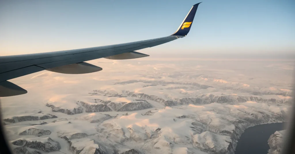 View from an airplane window over snowy mountains while flying to the best countries to visit in december
