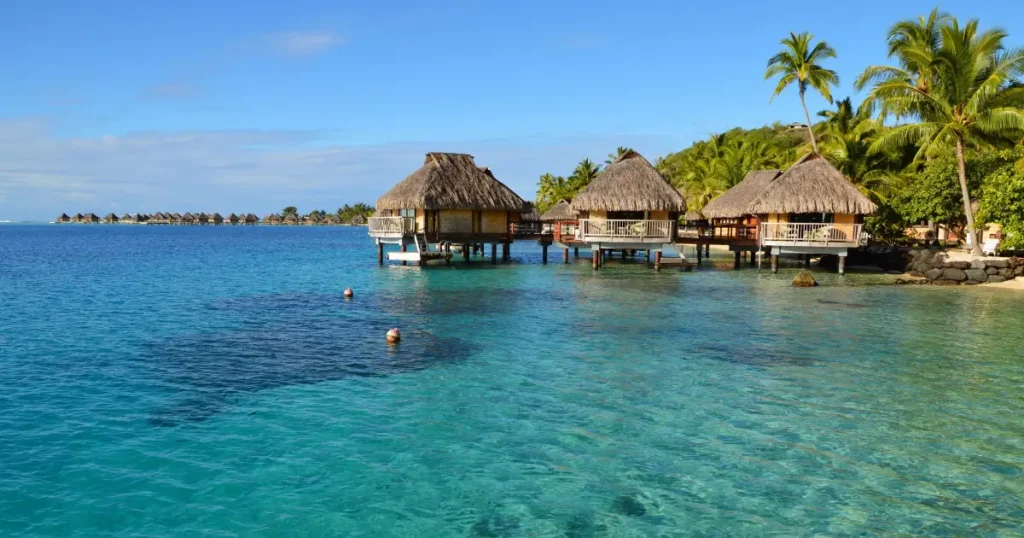 Overwater bungalows in a tropical lagoon, making it one of the best places to visit in december for a warm sunny getaway.