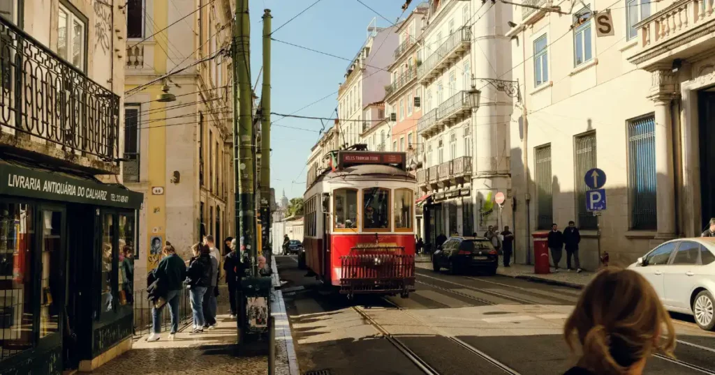 Iconic red vintage tram driving through Lisbon, one of the most charming december tourist destinations in Europe.